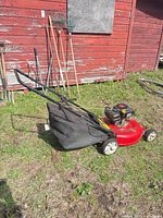 Full view of the Yard Machines red push mower with bag attached
