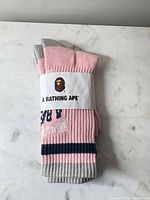 Front view of folded socks with branded paper wrap showing ape logo and A Bathing Ape text