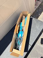 Vacuum components and cord inside open cardboard box
