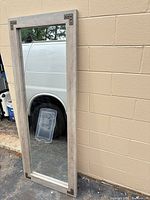 Front view of full-length mirror leaning against wall