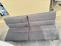 Front view of futon in sofa position showing gray fabric and stains