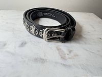 Belt coiled showing buckle and logo studs