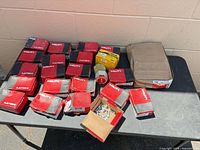 Overview of multiple Hilti boxes and loose pins on table