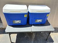 Two blue Igloo hard-sided coolers with white lids closed