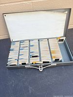 Open metal slide case showing rows of mounted slides