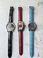 Three watches laid out showing straps and dials