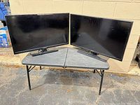 Both 32-inch TVs side by side on table