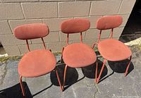 Front view of three matching orange dining chairs