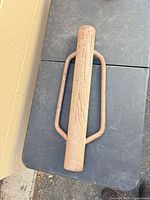 Top-down view of the full post driver showing handles and rusted finish