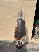 Full view of resin floor vase with decorative stems