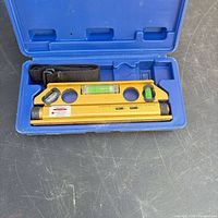 Laser level in blue case showing bubble vials and laser end