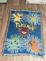 Front of blue Pokémon tapestry throw showing characters and logo