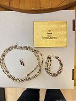 Full set laid out: necklace, bracelet, earrings, presentation box