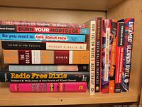 Shelf view showing horizontal stack of seven paperbacks including titles by Lee Maracle, Sean Cooper, Ijeoma Oluo, Robert B. Reich, Homer, Timothy B. Tyson and Roxane Gay