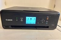 Front view of Canon TS5020 printer showing touchscreen lit, overall condition