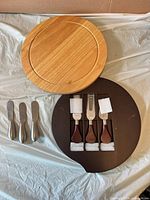 Light and dark round cheese boards with seven cheese knives, boxed and loose