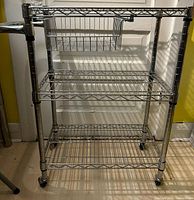 Front view of chrome wire rack showing three shelves and casters
