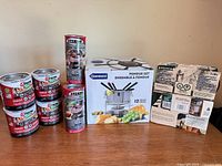 Full lot showing Danesco fondue set box, eight Sterno fuel cans and one Woods fuel box