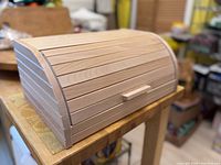 Three-quarter view of wooden bread box on table