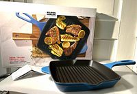 Pan displayed in front of branded retail box, leaflet visible