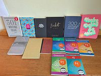 All fourteen notebooks, journals and puzzle books arranged on table