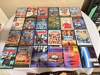 Full overhead view of 25 DVD cases arranged 5×5 on table