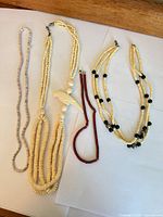 Four necklaces laid out showing overall styles and lengths