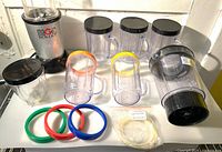 Overall lot showing motor base, cups, pitcher, lids, rings, gaskets