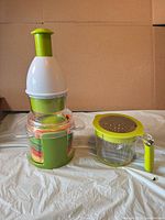 Chopper assembled next to handled measuring cup with grater lid