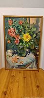 Full view of framed floral oil painting on table