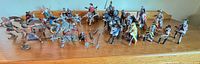 Full lot overview of mounted and unmounted figures and accessories spread on wooden surface