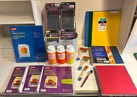 Group view of all items: marker packs, Mod Podge bottles, brushes, notebooks, sheet protectors