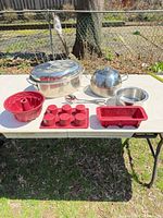 All cookware, bakeware and utensils displayed on table outdoors