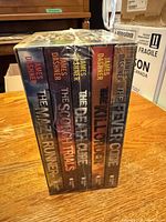 Shrink-wrapped book spines showing titles and author