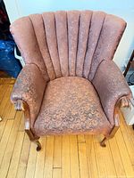 Front view showing upholstery, channel-back design, arms, cabriole legs