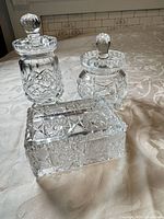 Three pieces of cut crystal: two lidded jars and one rectangular trinket box