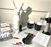 Full lot overview showing dispenser, chargers, two torches, ramekins, booklet