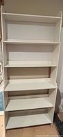 Full frontal view of white bookcase showing five shelves