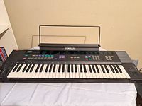 Front view of Yamaha DSR-1000 keyboard with music stand attached