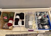 Four containers of assorted yarn skeins showing quantity and colour range