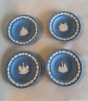 Set of four blue jasperware pin dishes showing white relief London scenes