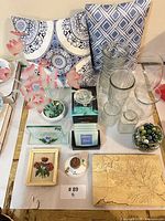 Group shot showing vases, pillows, framed print, dish, plaque and centerpiece