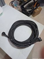 Coiled 50-ft black extension cord on table