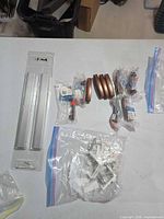 Overview showing 8 Amerock pulls, 2 packaged bar handles, bag of plastic brackets