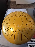 Top view of gold steel tongue drum showing 11 numbered tongues