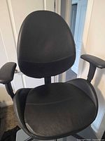 Front view of black Ikea faux leather office chair showing backrest, seat and arms