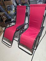 Two red zero-gravity chairs upright