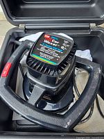 Polisher inside storage case showing handle and power switch