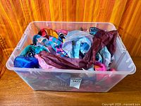 overall view of clear bin filled with colorful silk scarves