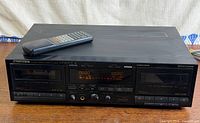 Front view of Pioneer CT-W550R double cassette deck with remote on top